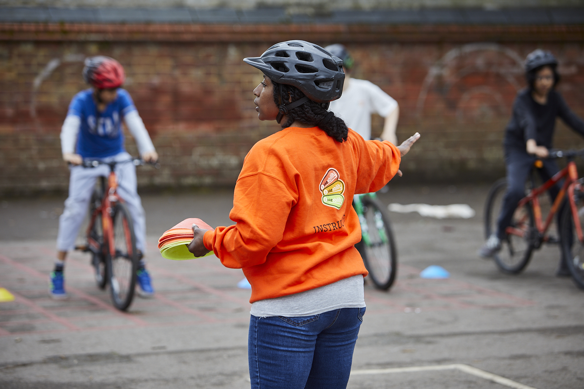 An instructor in an orange jumper