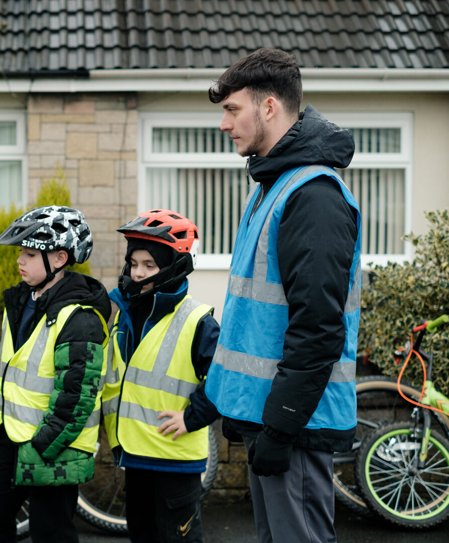 A Bikeability instructor standing with some riders