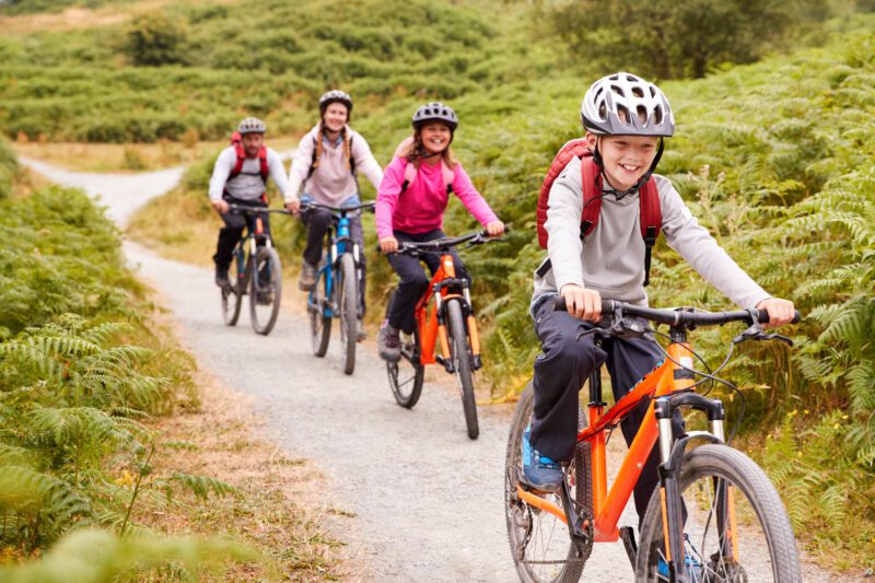 A family cycling on a gravel path