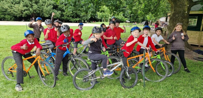 A group of students from Riddings Junior School. They are on their bikes wearing their school uniforms and giving a thumbs up.