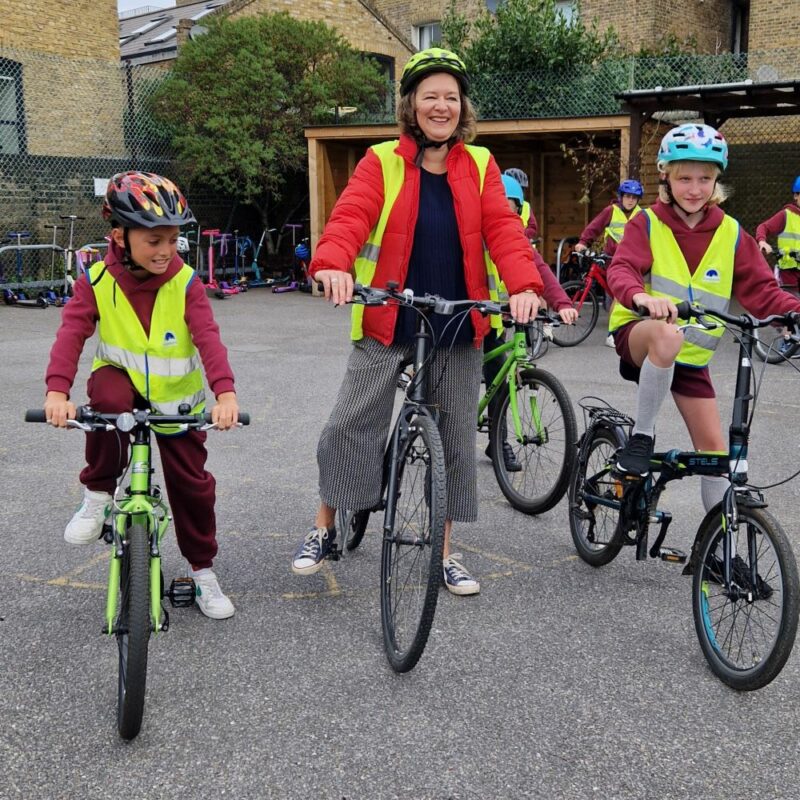 An MP and students in the playground on bikes