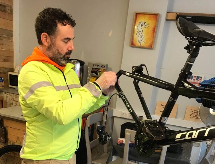 Instructor Jon working on a bike that is up on a stand