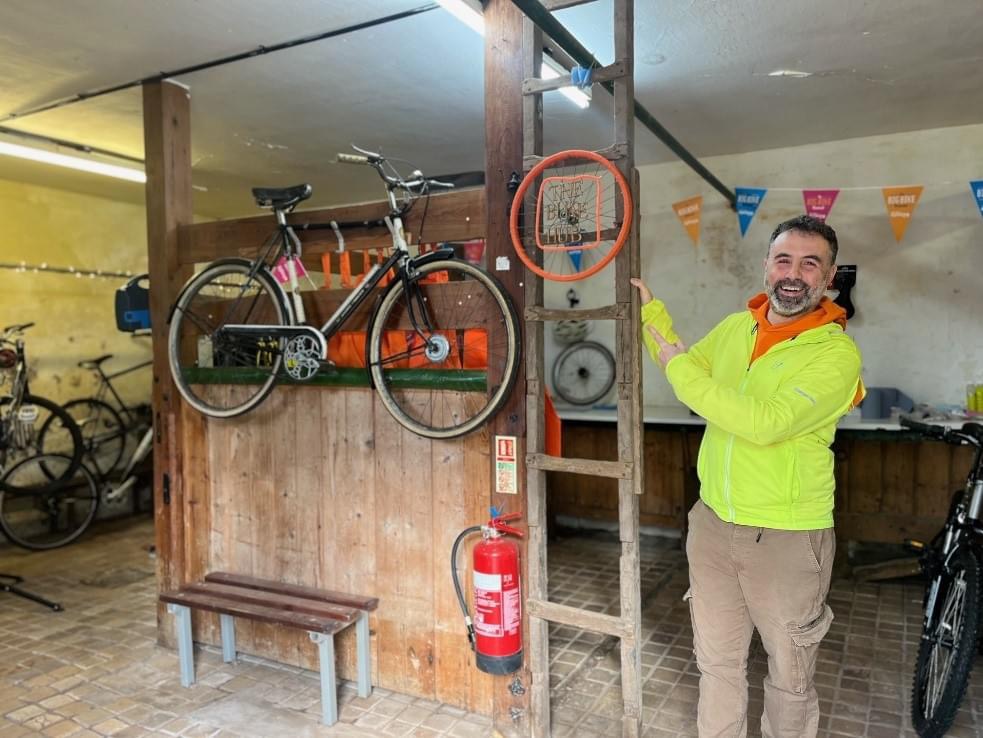 Instructor Jon standing in the Torbay Bike Hub next to a vintage bike smiling