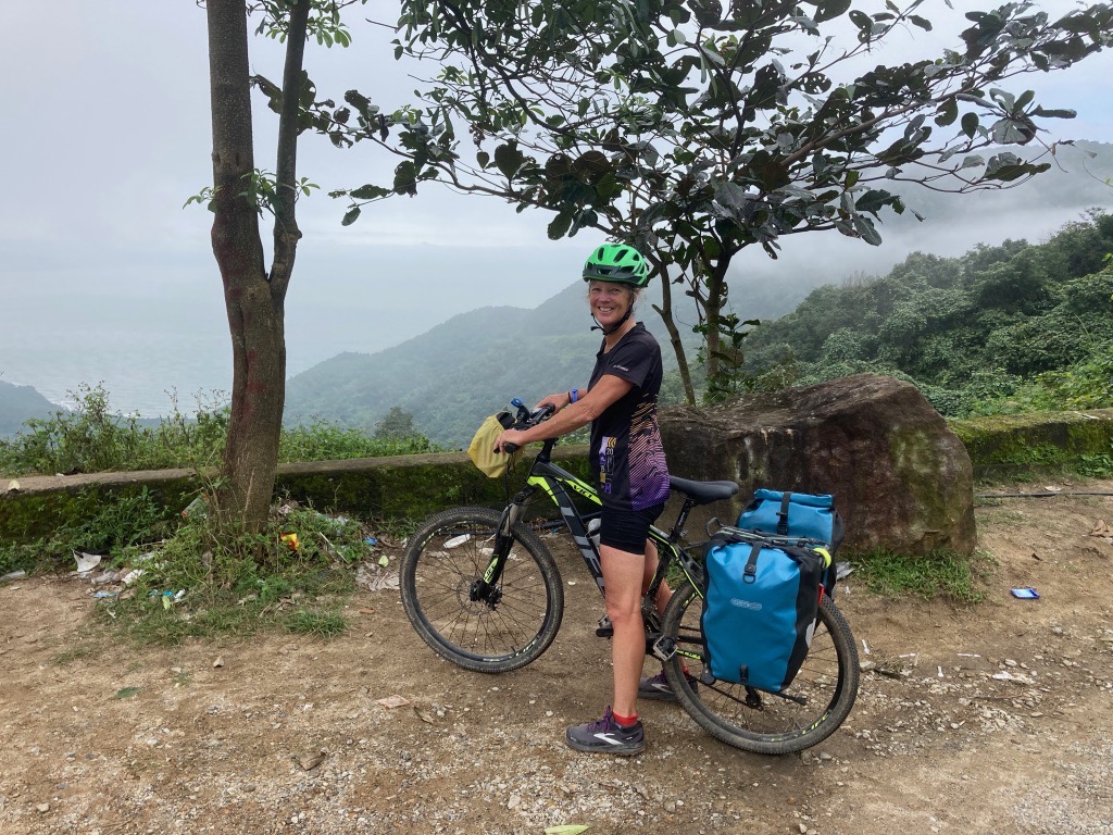 Jenny with her bike she is looking out over a mountain